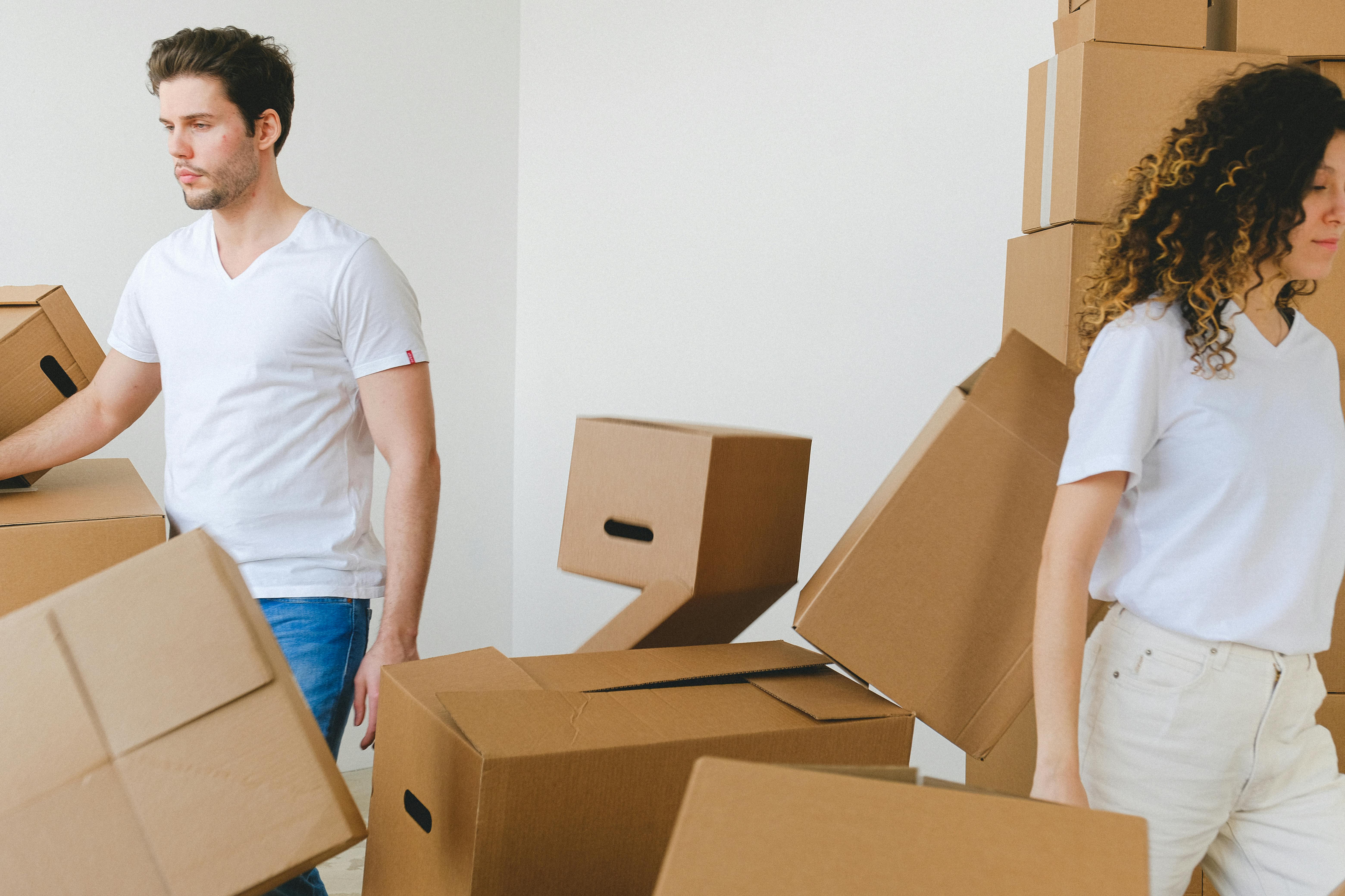 Couple moving boxes into new home